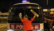 An anti-government demonstrator stands in fron of a police vehicle during a protest against the invocation of the emergency laws in Hong Kong, October 14, 2019. Reuters/Ammar Awad
 