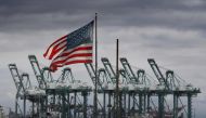 In this file photo taken on March 04, 2019 the US flag flies over shipping cranes  in Long Beach, California. AFP / Mark Ralston  