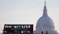 Commuters cross the River Thames' Waterloo Bridge into the City of London on March 21, 2018, backdropped by the dome of St Pauls Cathedral. AFP / Daniel Leal-Olivas