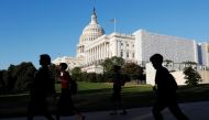 People walk past the U.S. Capitol Building in Washington, U.S., October 15, 2019. REUTERS/Carlos Jasso
 