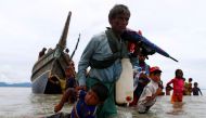 A Rohingya refugee pulls a child as they walk to the shore after crossing border by boat through the Bay of Bengal in Shah Porir Dwip, Bangladesh, September 10, 2017. Reuters / Danish Siddiqui