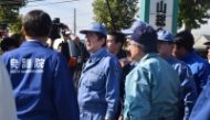 Japan's Prime Minister Shinzo Abe (C) inspects an area hit by Typhoon Hagibis last week in Koriyama, Fukushima prefecture on October 12, 2019. AFP