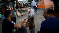 A boy selling candies and cigarettes gestures to the camera as he argues with migrants from India outside of Siglo XXI migration facility in Tapachula, Mexico, May 13, 2019. REUTERS/Andres Martinez Casares/File Photo