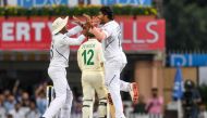 India's Umesh Yadav (R) celebrates with teammate Mayank Agarwal (L) as South Africa's Quinton de Kock (C) walks back to the pavilion after being dismissed during the second day of the third and final Test match between India and South Africa at the Jharkh