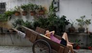 A man sleeps in a cart near a market in the traditional neighbourhood of Yuexiu in Guanghzou, China, September 8, 2019. Reuters/Jorge Silva