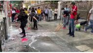 People and protesters help cleaning up the blue dye that stained steps of the Kowloon Masjid and Islamic Centre in Hong Kong October 21, 2019 in this still image obtained from social media video. Broadcast News Network/Hong Kong Baptist University via REU