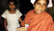Rukmani Naik of West Bengal state poses with a picture of her 14-year-old daughter who left their home in the Diana Tea Estate to work in another city, January 12, 2017. Reuters
