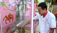 This photograph taken on October 23, 2019 shows a restaurant worker loading crabs into a claw machine at a seafood restaurant in Singapore. AFP / Roslan Rahman
 