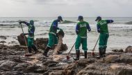 Municipal workers remove spilled crude oil at Pedra do Sal beach in Salvador, Bahia state, Brazil, on October 23, 2019.  AFP / Antonello Veneri 