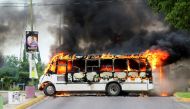 FILE PHOTO: A burning bus, set alight by cartel gunmen to block a road, is pictured during clashes with federal forces following the detention of Ovidio Guzman, son of drug kingpin Joaquin 