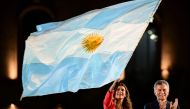 Argentina's President and presidential candidate of the Juntos por el Cambio party, Mauricio Macri (R), applauds as First Lady Juliana Awada was a national flag during the closing rally of his campaign in Cordoba, Argentina, on October 24, 2019. Argentina