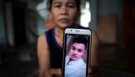 Hoang Thi Ai, 48, mother of Hoang Van Tiep who is one of the suspected victims of the 39 people found dead in a refrigerated truck in Britain, shows a picture of him on her mobile phone at her house, in Dien Chau district, Nghe An province, Vietnam, Octob