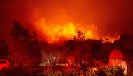 Firefighters survey Soda Rock Winery as it begins to burn during the Kincade fire in Healdsburg, California on October 27, 2019.  / AFP / Josh Edelson 