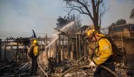 Firefighters battle the Getty Fire in houses on fire in Brentwood, California on October 28, 2019.  AFP / Apu Gomes 