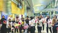 Qatar basketball team’s players and officials pose for a group photo upon their return at the Hamad International Airport.