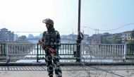 A security personnel looks on as he stands guard during a lockdown in Srinagar on October 25, 2019. Suspected militants shot dead two non-local drivers and set their apple trucks ablaze in Indian-Administered Kashmir, police said on October 25, the latest