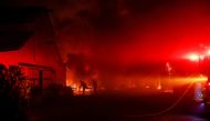Firefighters work to contain a burning structure during the wind-driven Kincade Fire in Windsor, California, U.S. October 27, 2019. REUTERS/Stephen Lam

