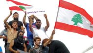 Lebanese demonstrators wave the national flag during a protest against dire economic conditions in downtown Beirut on October 18, 2019. AFP / Ibrahim Amro