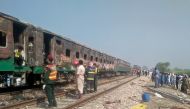 People and rescue workers gather near the site after a fire broke out in a passenger train and destroyed three carriages near the town of Rahim Yar Khan, Pakistan October 31, 2019. REUTERS/Stringer
 