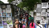 People light candles and pray for their relatives at a cemetery during the annual observance of All Saint's Day in Manila on November 1, 2019. Millions of Filipinos flocked to cemeteries to visit and pray at the graves of their loved ones to mark the holi