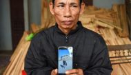 Nguyen Dinh Gia, father of 20-year-old Nguyen Dinh Luong who is feared to be among the 39 people found dead in a truck in Britain, poses with his son's photograph at their house in Can Loc district of Vietnam's Ha Tinh province on October 29, 2019.  AFP /