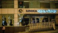A pedestrian walks past China's Xinhua News Agency, after it was damaged by protesters, in Hong Kong on November 2, 2019. AFP / Anthony WALLACE
