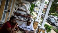 Baltimore resident and gunshot survivor Antonio Pinder (R), 31, speaks during an interview as his uncle Lamont Medley (L) listens West Baltimore on September 12, 2019. AFP / Eric Baradat