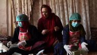 In this photo taken on October 8, 2019, Afghan entrepreneur Marghuba Safi (C) sits with female workers arranging bars of soap at her organic skin care company in Kabul.  AFP / Wakil Kohsar