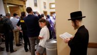 An Orthodox Jewish man supporting a religious exemption to childhood vaccinations pauses to pray in a hallway inside New York State Supreme Court during a hearing challenging the constitutionality of the NY State Legislature's repeal of the religious exem