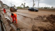 Workers remove mud from the N-11 road after floods caused by torrential rain north of Barcelona, Spain, Oct. 23, 2019. Reuters/Albert Gea