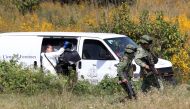 A team of forensic experts work in the site where seven bodies were found inside three abandoned vehicles on the way to Ocotillo, in Tonala, Mexico, on November 6, 2019. AFP / Ulises Ruiz
 