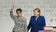 Annegret Kramp-Karrenbauer greets delegates while she stands next to Angela Merkel after she has been elected as new CDU party leader in Hamburg on December 7, 2018. Abdülhamid Ho?ba? / Anadolu Agency