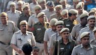 A man carries a child as police officers conduct a flag march in a street outside Jama Masjid, before Supreme Court's verdict on a disputed religious site claimed by both majority Hindus and Muslim in Ayodhya, in the old quarters of Delhi, India, November