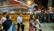 Locals pass police in riot gear during a standoff with protesters in Mong Kok, after Chow Tsz-lok, 22, a university student, died after he fell during a protest, at Tseung Kwan O, Hong Kong, China November 8, 2019.  REUTERS/Thomas Peter