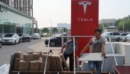 Workers carry building materials for a new Tesla showroom in Guangzhou, Guangdong province, China October 25, 2019. Picture taken October 25, 2019. REUTERS/Yilei Su