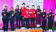 The podium winners of the Junior Women’s Skeet Team event, posing for a photograph at the Losail Shooting Range yesterday. Team Qatar won the bronze medal while China finished on top. India won the silver. BOTTOM: Shooters in action. Picture: Ebrahim Kutt