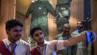 Students take a selfie in front of the statue of Indian pilot Wing Commander Abhinandan Varthaman (2R) whose plane was shot down over Kashmir earlier this year, put on display at Pakistan Air Force Museum in Karachi on November 12, 2019. AFP / Asif Hassan
