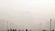 People walk in front of the smog covered India Gate war memorial in New Delhi, India, November 12, 2019. REUTERS/Anushree Fadnavis