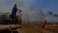Tinonee resident Brian Acheson sets up his tip truck as a makeshift fire truck to assist residents fighting spot and grass fires in the Hillville area near Taree, NSW, Australia, November 13, 2019. AAP Image/Dean Lewins/via REUTERS 