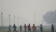 Youths play football near India Gate under heavy smog conditions in New Delhi on November 12, 2019. / AFP / Money Sharma 