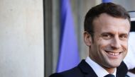 France's President Emmanuel Macron smiles as he waits for guests at the Elysee presidential palace prior to a working lunch as part of the Paris Peace Forum, on November 12, 2019 in Paris. / AFP / LUDOVIC MARIN