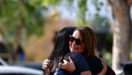 Women embrace in Central Park after a shooting at Saugus High School in Santa Clarita, California on November 14, 2019. / AFP / Frederic J. BROWN 