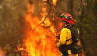 A firefighter looks on as the Carr Fire moves through the area on July 28, 2018 in Redding, California. Justin Sullivan / Getty Images / AFP