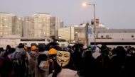 A protester wearing a Guy Fawkes mask stands on the bridge above the Cross Harbour Tunnel during clashes with police outside Hong Kong Polytechnic University (PolyU) in Hong Kong, China November 17, 2019. Reuters/Adnan Abidi