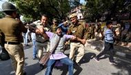 Security personnel hold a Jawaharlal Nehru University (JNU) student during a students protest against hostel fee hike, as security measures have been reinforced from JNU campus along the road to the march protest, in New Delhi on November 18, 2019. AFP / 