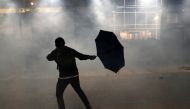 An anti-government demonstrator reacts amid tear gas during protests at Tsim Sha Tsui, in Hong Kong, China, November 18, 2019. Reuters/Athit Perawongmetha
 