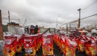 People packaging smokeless fuel at a sales spot in Ulaanbaatar, the capital of Mongolia, on October 19, 2019.  AFP / Byambasuren Byamba-Ochir 
