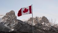 In this file photo taken on February 6, 2019 the Canadian flag flies over the Canadian Rockies at the Canmore Nordic Center in Canmore, Canada.  AFP / Don Emmert 
 
 