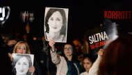 Protesters hold up placards and pictures of the late journalist Daphne Caruana Galizia as they gather outside the prime minister's office in Valletta, Malta on November 20, 2019.  AFP / Matthew Mirabelli 