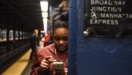  A woman looks at her phone while waiting on the platform at the Broadway Junction subway station on November 14, 2019 in New York City.  Stephanie Keith/Getty Images/AFP